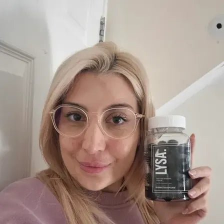 Jemma holding a jar of Lysa Wellness gummies